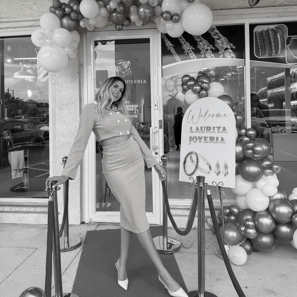 Woman in a yellow dress standing in front of a decorated entrance with balloons and a red carpet.